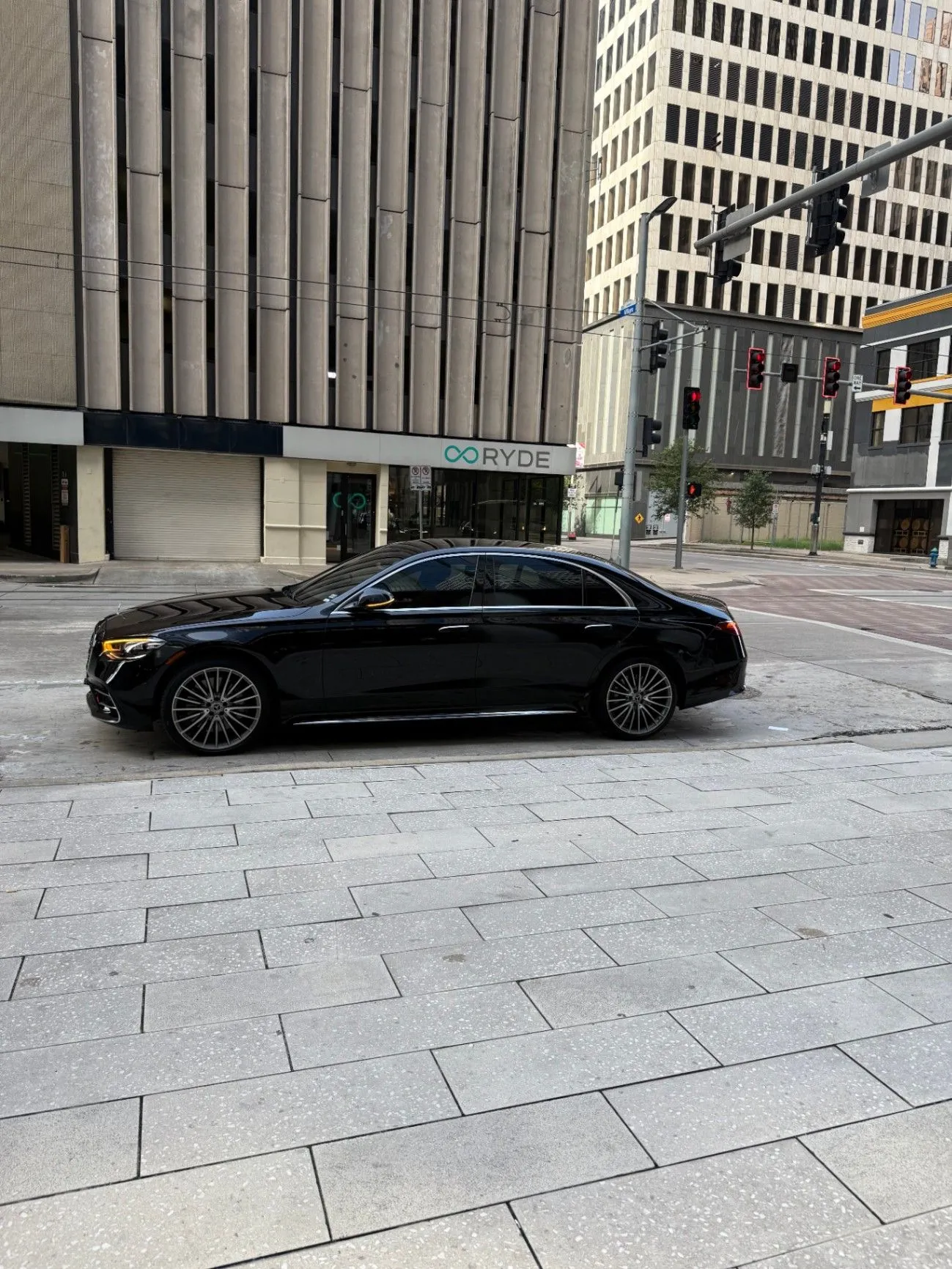 Black executive sedan parked in downtown Houston beneath the surrounding office towers